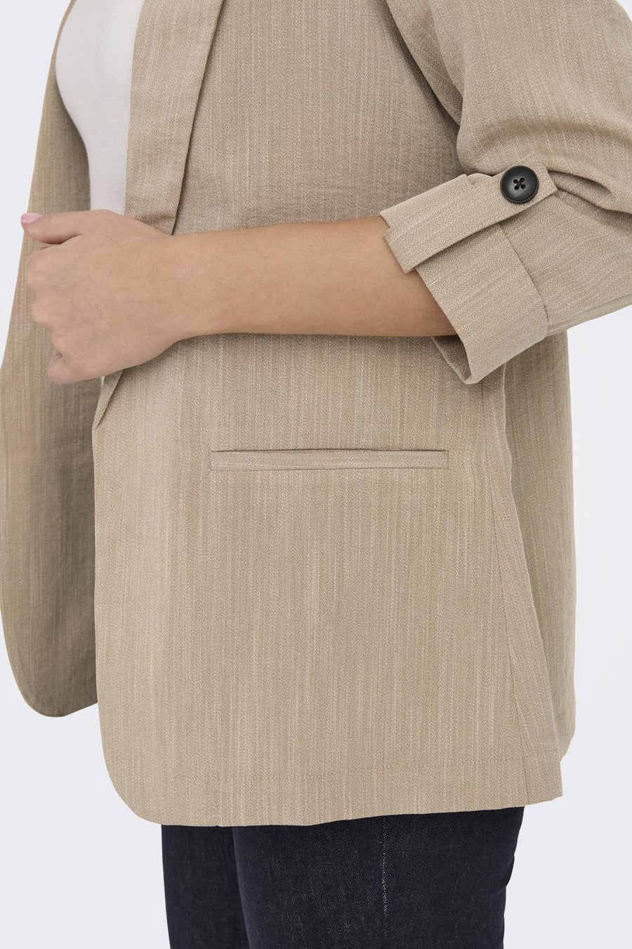 Blazer beige by ONLY, avec manches retroussées et poche passepoilée, en gros plan.
