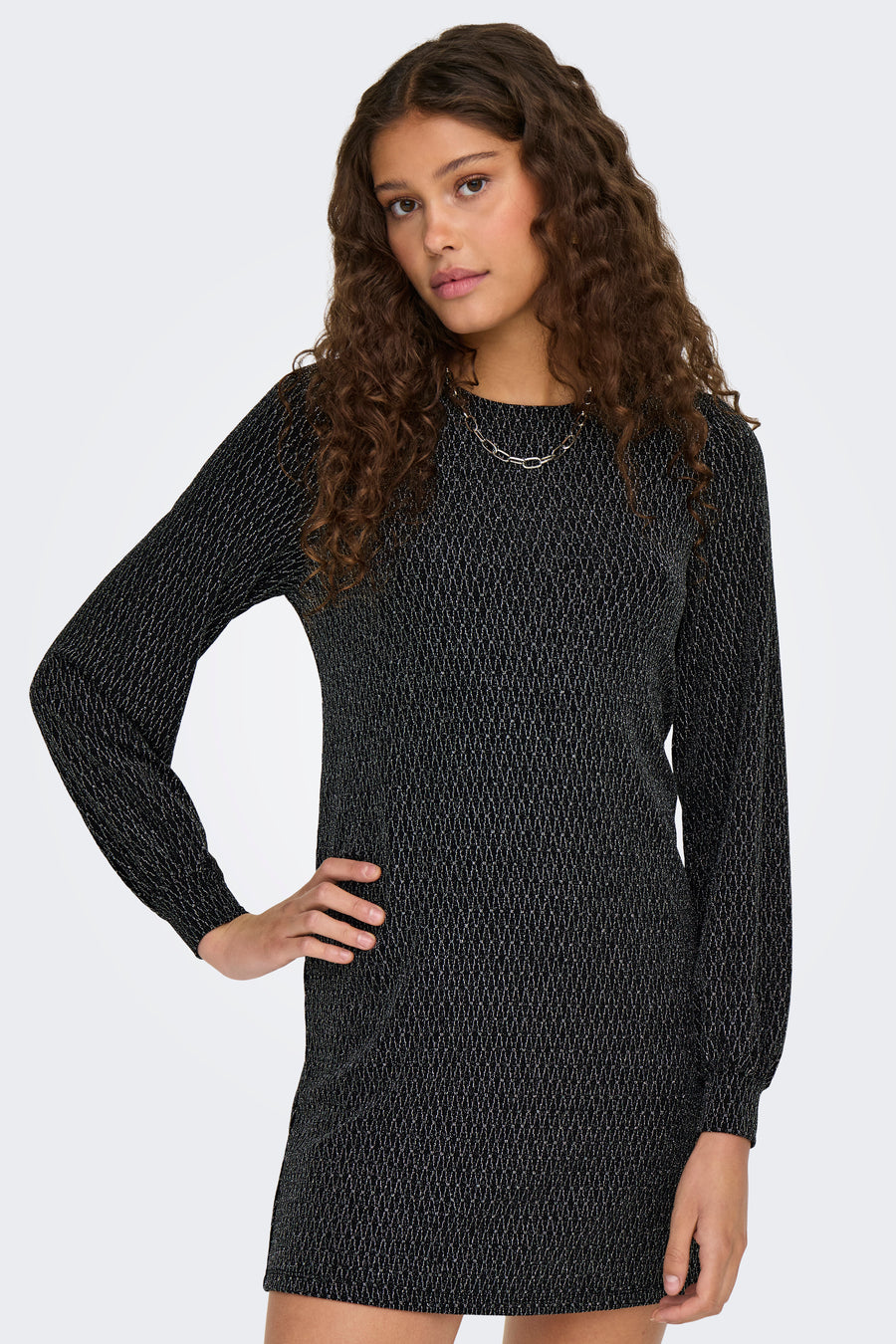 Robe noire à manches longues par ONLY, avec un motif géométrique discret et un collier argenté.
