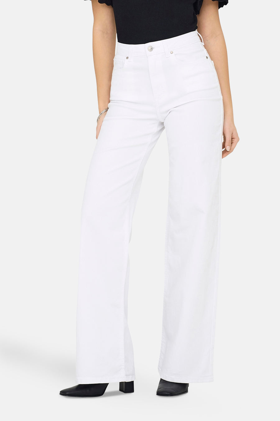 Jean large blanc de ONLY, porté avec un haut noir et des chaussures en cuir noires