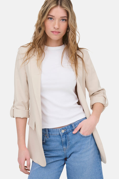 Blazer beige ONLY®, porté sur un t-shirt blanc et un jean bleu.
