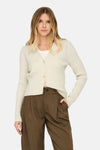 Cardigan beige de ONLY, avec boutons décoratifs en forme de cœur, porté sur un t-shirt et un pantalon marron.
