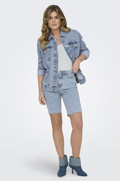 Bermuda bleu de ONLY, porté avec une veste en jean et des bottines à talons assorties.