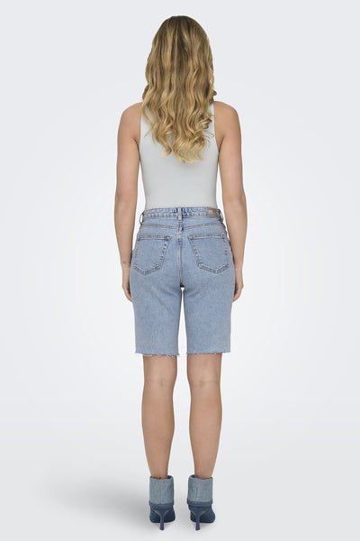 Bermuda bleu de ONLY, porté avec un body uni, et des bottines en denim.