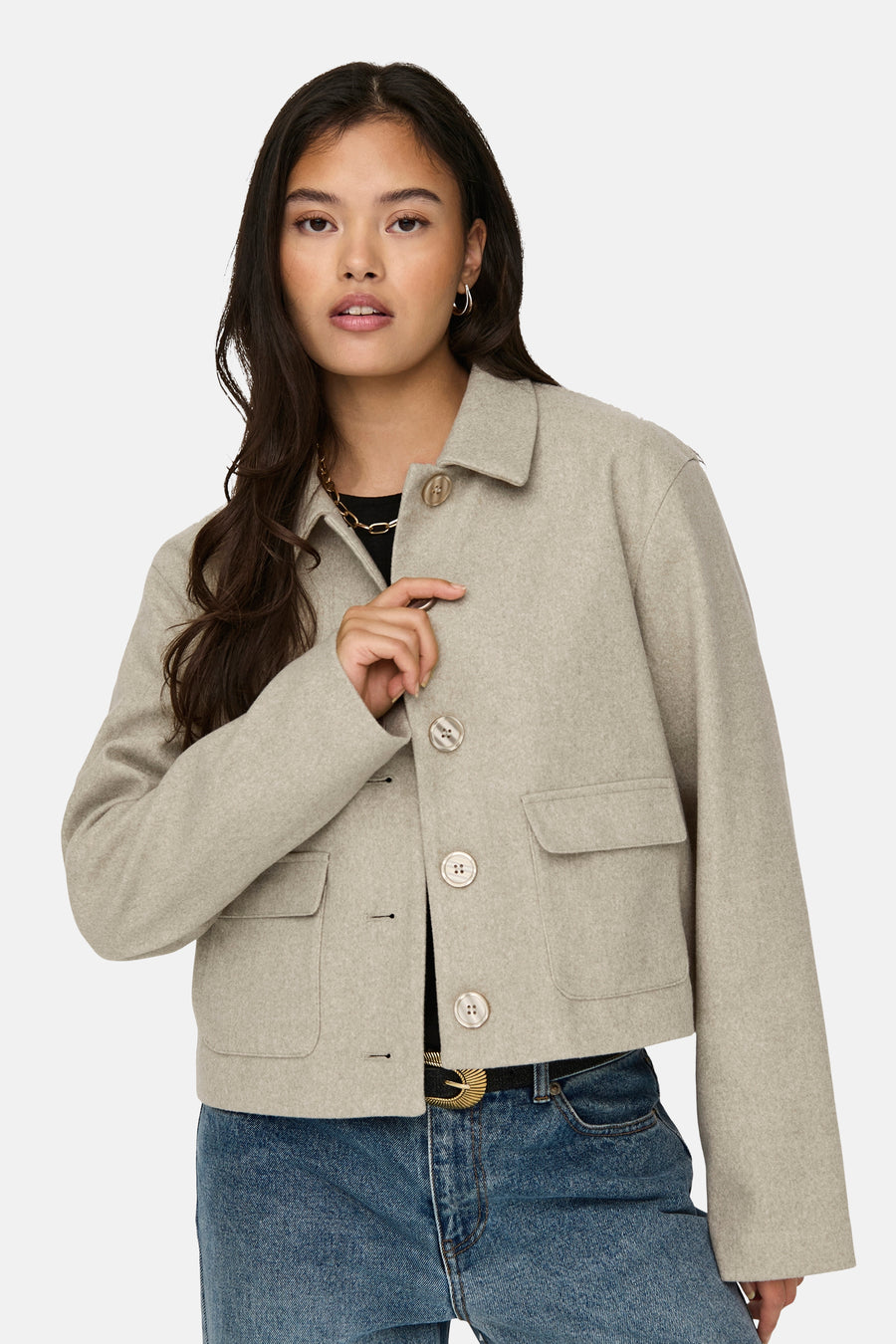 Veste courte beige de JDY, avec boutons, poches plaquées et porté sur un jean taille haute.

