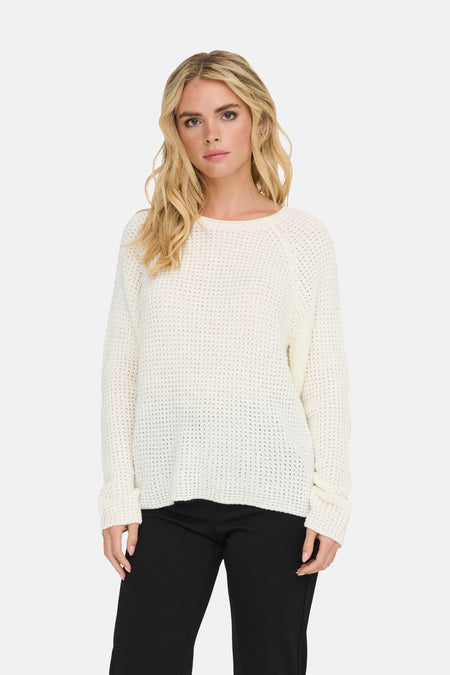 Pull à col rond blanc de JDY porté avec un pantalon noir classique.