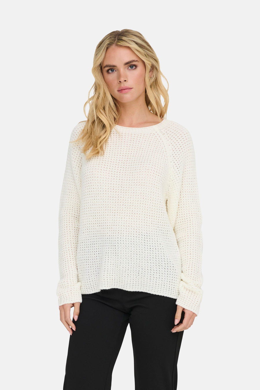 Pull à col rond blanc de JDY porté avec un pantalon noir classique.