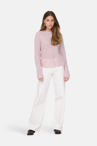Roze rondehals trui van JDY, met een gebreide textuur en gedragen met een witte broek.