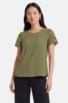 T-shirt vert olive de JDY à manches courtes ajourées, porté par une femme avec un pantalon noir.