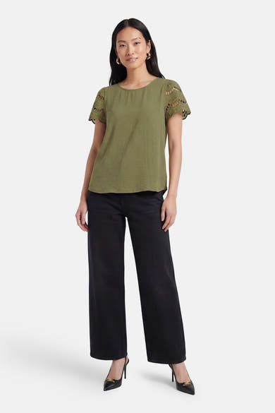 T-shirt vert texturé de JDY avec manches courtes à motifs ajourés, porté sur un pantalon noir.