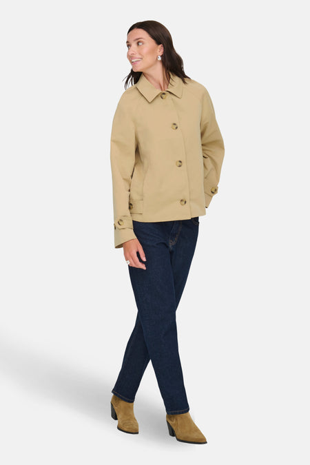 Veste courte beige de JDY avec boutons, portée avec un jean bleu foncé et des bottines en daim marron.