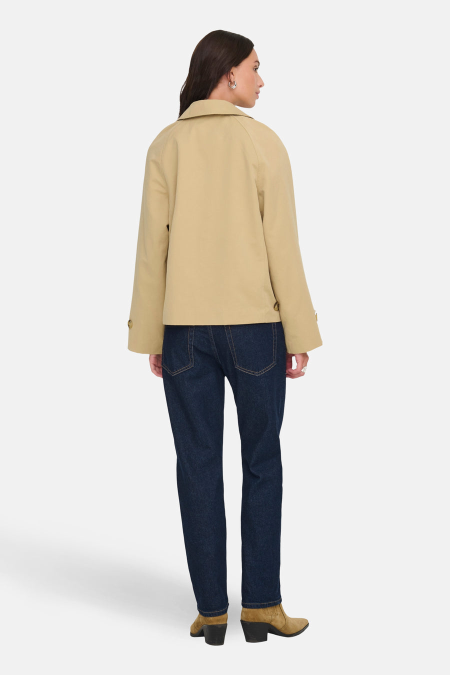 Veste courte beige de JDY, avec des manches longues, portée avec un jean bleu foncé et des bottines en daim marron.