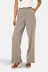 Beige kostuumbroek van ONLY, gedragen met een witte top met ruches en sleehakken.