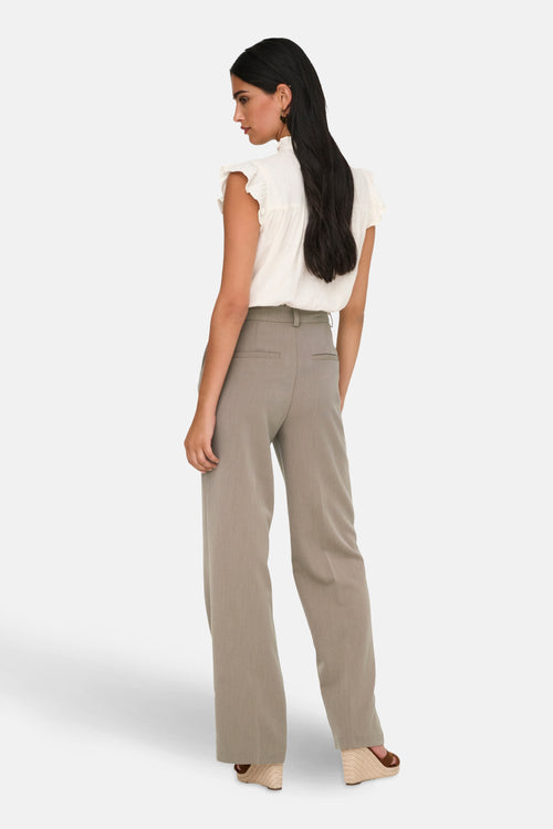 Pantalon de costume beige de ONLY®, coupe ample et taille haute, porté avec un haut blanc.