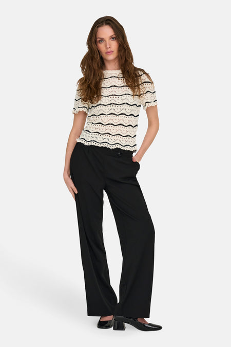 Ecru T-shirt met zwarte strepen van ONLY, gedragen met een zwarte high-waist broek en zwarte schoenen.