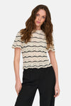 T-shirt écru en crochet de ONLY, avec des rayures noires et porté avec un pantalon noir.
