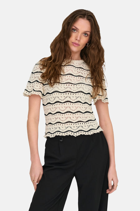 Ecru gehaakt T-shirt van ONLY, met zwarte strepen en gedragen met een zwarte broek.