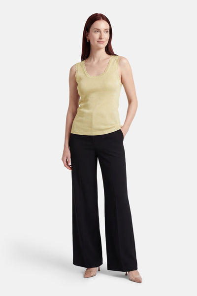 Débardeur vert de ONLY® avec bordure en dentelle, porté avec un pantalon noir ample et des chaussures à talons claires.