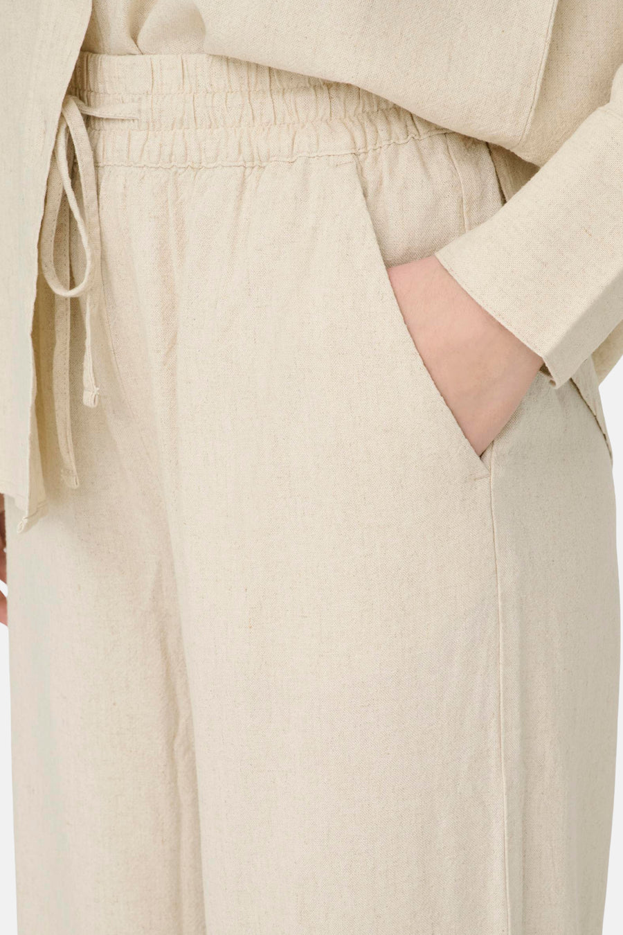 Beige broek van JDY, met elastische tailleband met trekkoord, linnen textuur, gedragen met een crèmekleurig overhemd.
