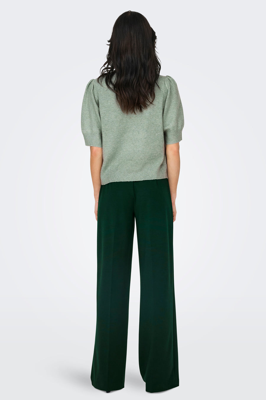 Groene trui met ronde hals van ONLY, met korte pofmouwen, gedragen met een donkergroene broek.