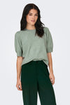 Groene trui met ronde hals van ONLY, gedragen met een donkergroene broek.