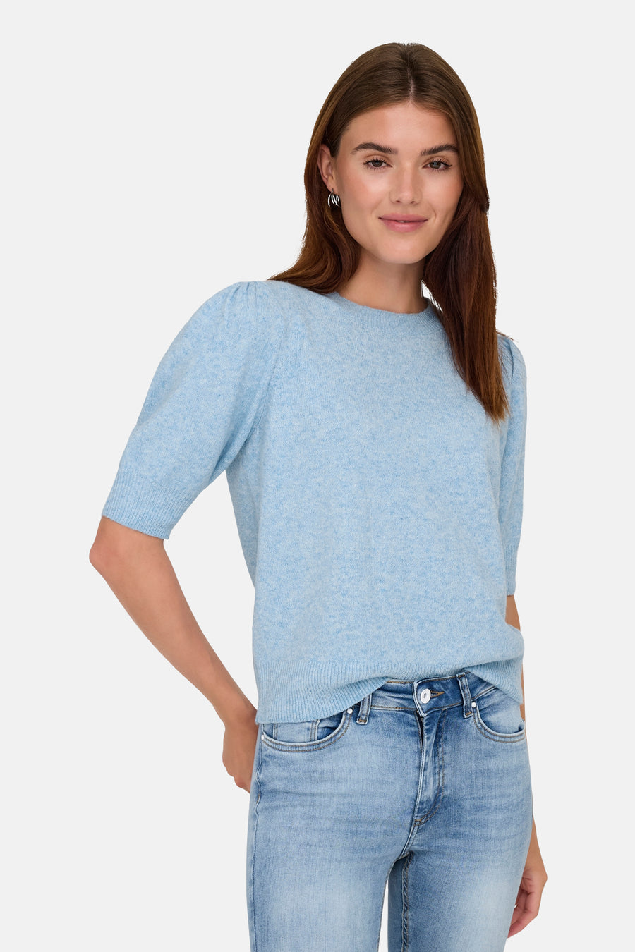 Pull à col rond bleu clair de ONLY, porté avec un jean bleu et des boucles d'oreilles argentées.
