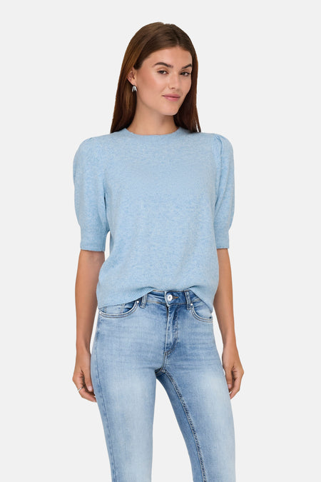 Lichtblauwe rondehals trui van ONLY, gedragen met een lichtblauwe jeans en lange oorbellen.