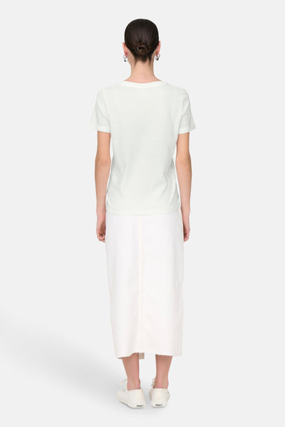 T-shirt blanc à manches courtes de JDY, porté avec une jupe longue blanche et des baskets assorties, vue de dos.
