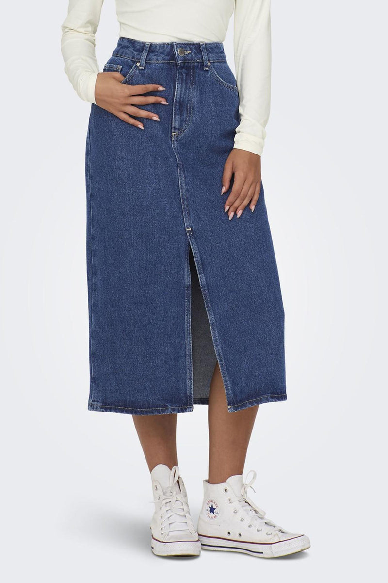 Middenblauwe spijkerrok van ONLY, met split aan de voorkant, gedragen met een top met lange mouwen en hoge sneakers.