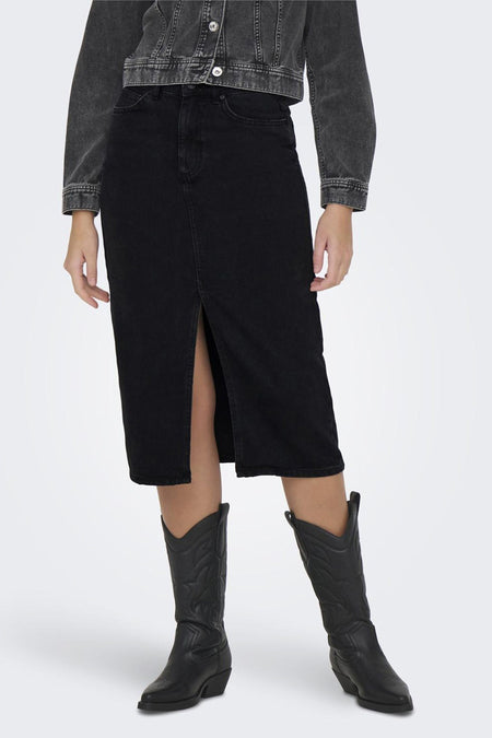 Zwarte midi-rok van ONLY, met split aan de voorkant, gedragen met een spijkerjasje en zwarte cowboylaarzen.