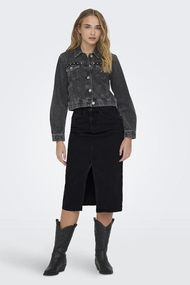 Jupe noire midi de ONLY, fendue sur le devant, portée avec une veste en jean et des bottes de cowboy noires.