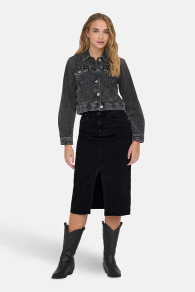 Zwarte midi-rok met split van ONLY, gedragen met een verweerd spijkerjack en zwarte cowboylaarzen.