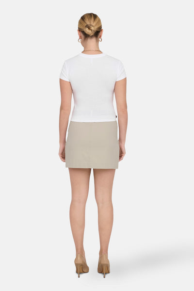 T-shirt blanc à manches courtes de ONLY®, porté avec une jupe beige et des escarpins assortis, vue de dos.
