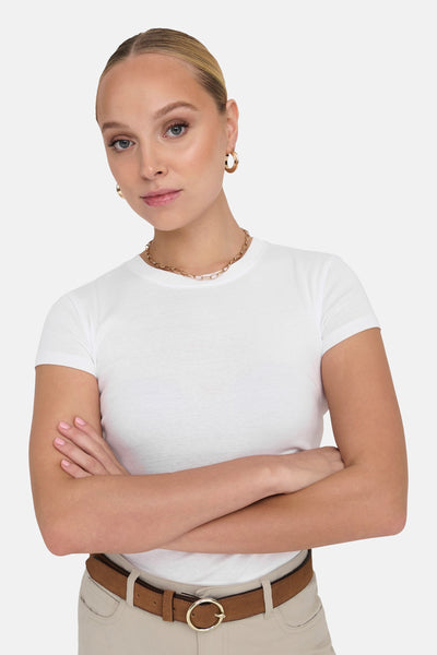 T-shirt blanc à manches courtes de ONLY, porté avec un collier chaîne et des créoles dorées.
