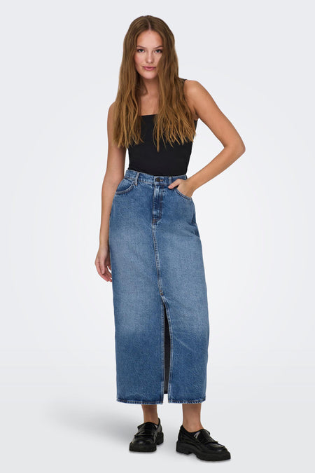 Blue denim long skirt with front slit, high waist, and classic five-pocket styling, worn with black top and chunky loafers in full-length front view.