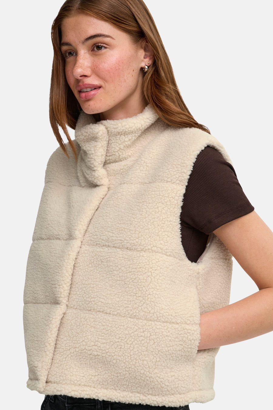 Cream shearling bodywarmer with turtleneck and quilted texture, worn over brown short-sleeve top, side view