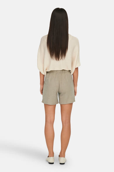 Short beige de JDY, porté avec un pull couleur crème et des chaussures plates ivoire, vue de dos.
