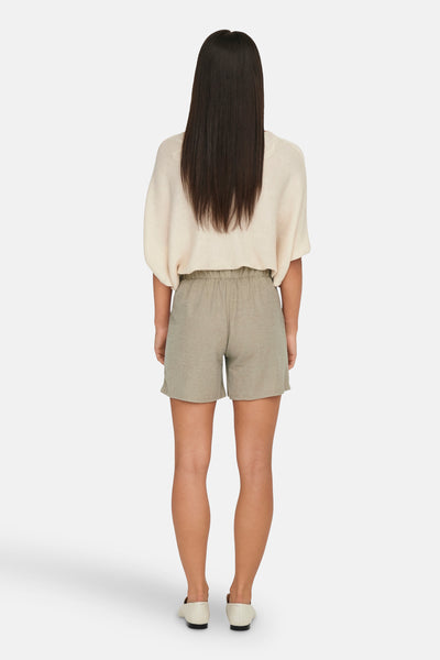 Short beige de JDY, porté avec un pull couleur crème et des chaussures plates ivoire, vue de dos.
