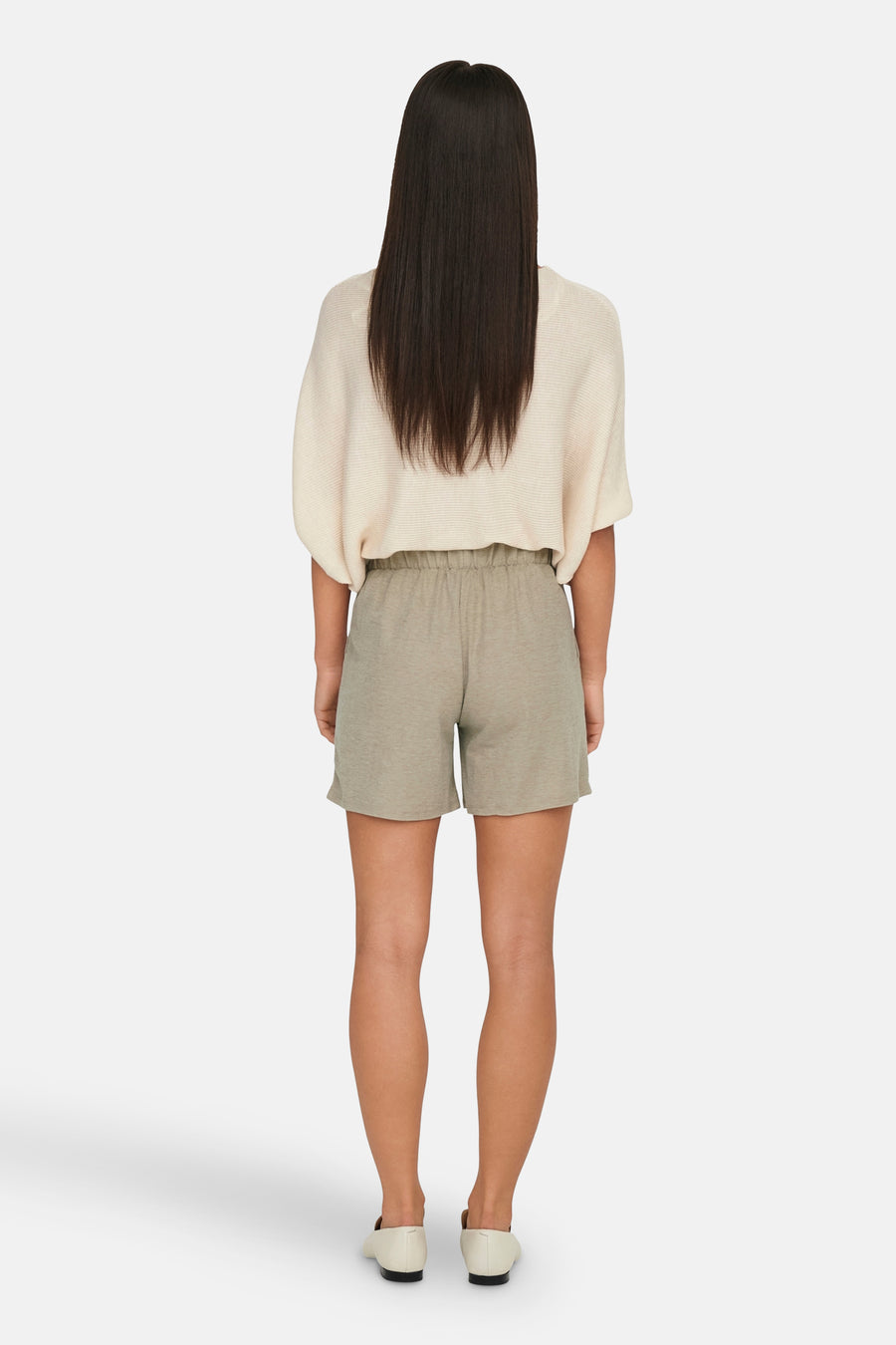 Short beige de JDY, porté avec un pull couleur crème et des chaussures plates ivoire, vue de dos.
