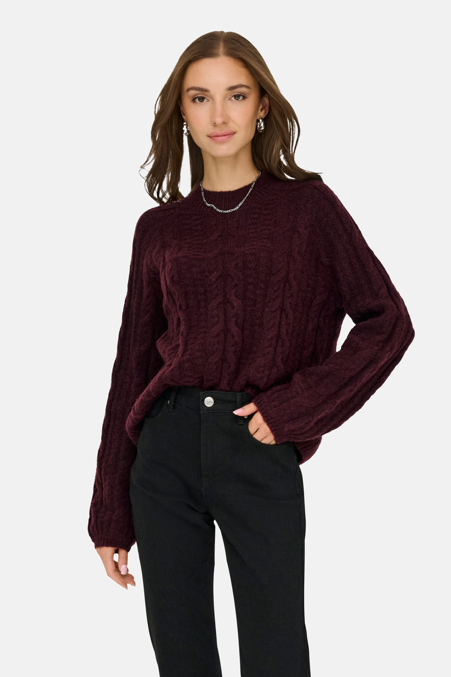 Rode coltrui van JDY, in kabelsteek, gedragen met een zwarte jeans en zilveren sieraden.