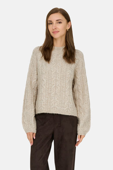 Beige coltrui van JDY, met kabelstructuur en bruine broek.