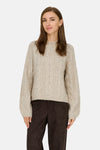Beige coltrui van JDY, met kabelstructuur en bruine broek.