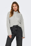 Grijze coltrui van ONLY, gedragen met een zwarte jeans en zwarte laarzen met hak.
