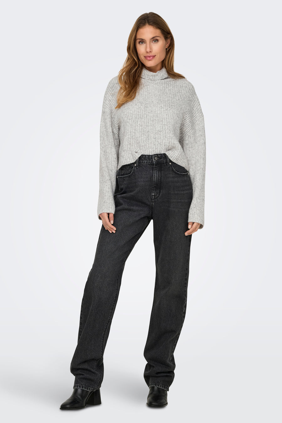 Pull à col roulé gris de ONLY, porté avec un jean noir et des bottes à talons noirs.