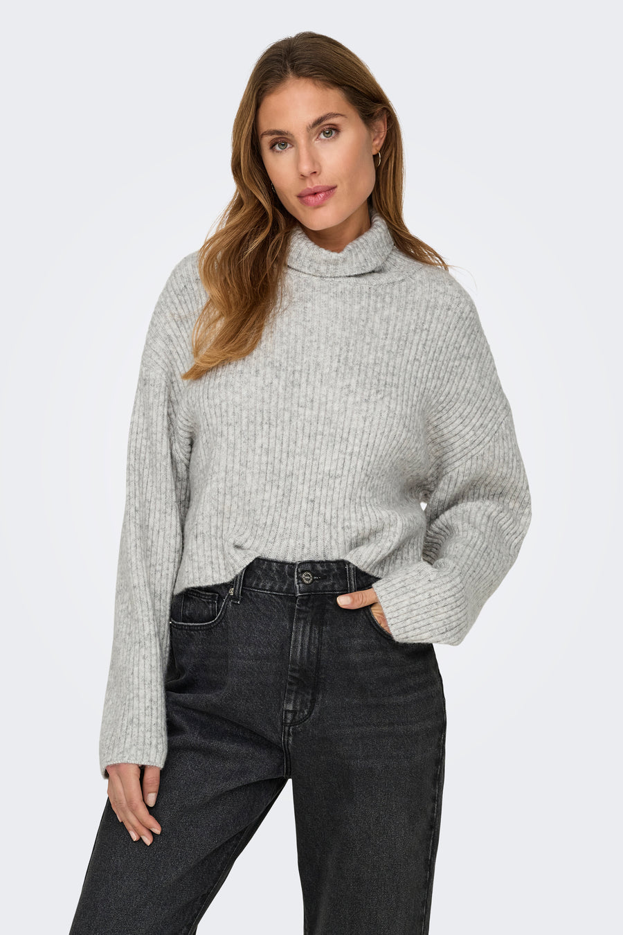 Grijze coltrui van ONLY, gedragen met een zwarte jeans, op een effen achtergrond.