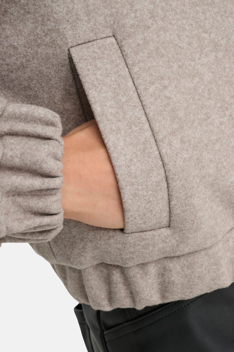 Veste courte beige de ONLY, avec une main dans la poche, et manches resserrées.