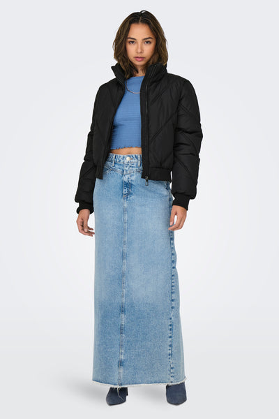 Veste courte noire de ONLY, portée avec un haut bleu et une longue jupe en denim.