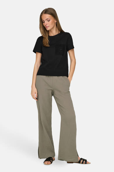 T-shirt noir à manches courtes de JDY avec poche en dentelle et pantalon vert olive.
