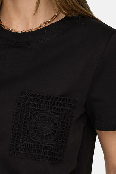 T-shirt noir à manches courtes de JDY avec une poche en crochet sur la poitrine et un collier doré.