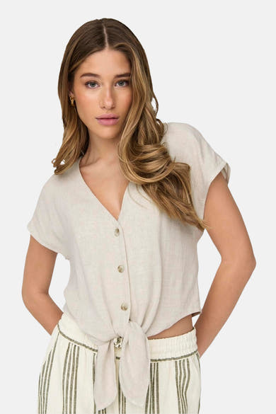 Beige blouse met korte mouwen van ONLY®, geknoopt aan de voorkant, gedragen met een gestreepte broek.