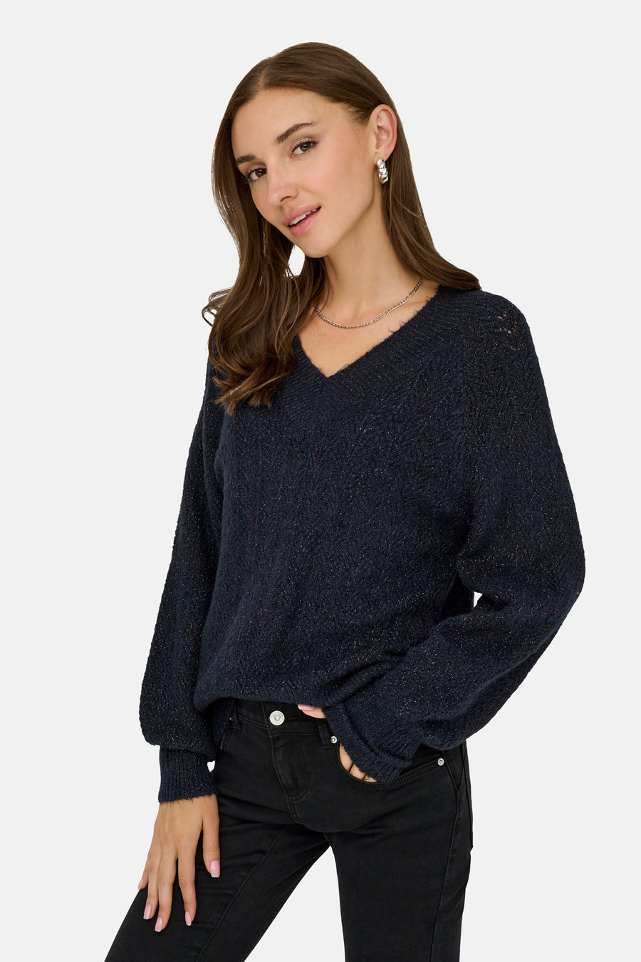 Pull à col en V bleu de ONLY, porté avec un jean noir et un collier argenté.
